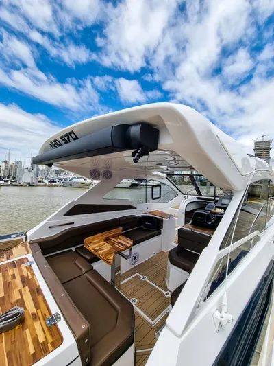  Yacht Photos Pics 2025 NHD 365 Open Deck HT yacht with luxurious seating and wooden accents, docked under a blue sky.
