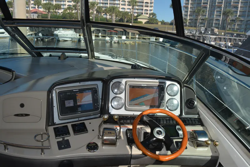 Knot On Call Yacht Photos Pics 2007 Sea Ray 44 Sundancer helm with navigation screens and wooden steering wheel.