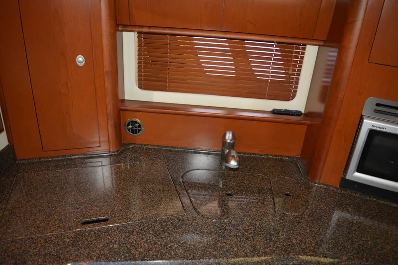 Knot On Call Yacht Photos Pics 2007 Sea Ray 44 Sundancer kitchen with granite countertop and wooden cabinetry.