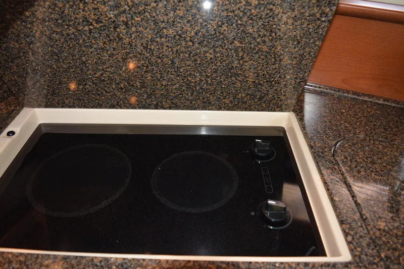 Knot On Call Yacht Photos Pics 2007 Sea Ray 44 Sundancer kitchen with sleek black cooktop and granite countertops.