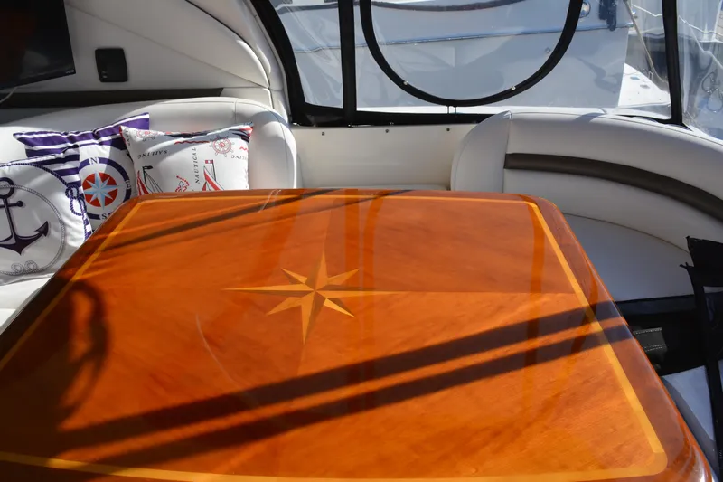 Knot On Call Yacht Photos Pics Luxurious interior of 2007 Sea Ray 44 Sundancer with nautical-themed cushions and polished wood table.