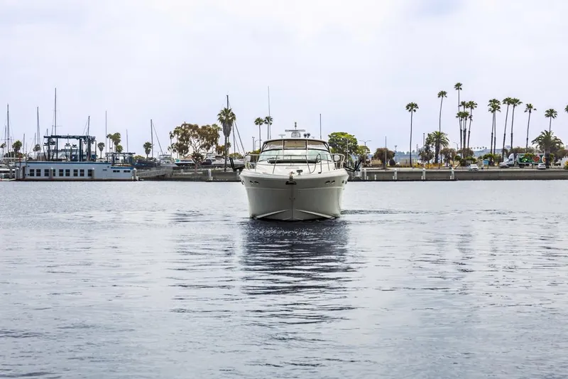 Yacht Photos Pics Sea Ray 510 Sundancer 2000 yacht cruising in a marina with palm trees in the background.