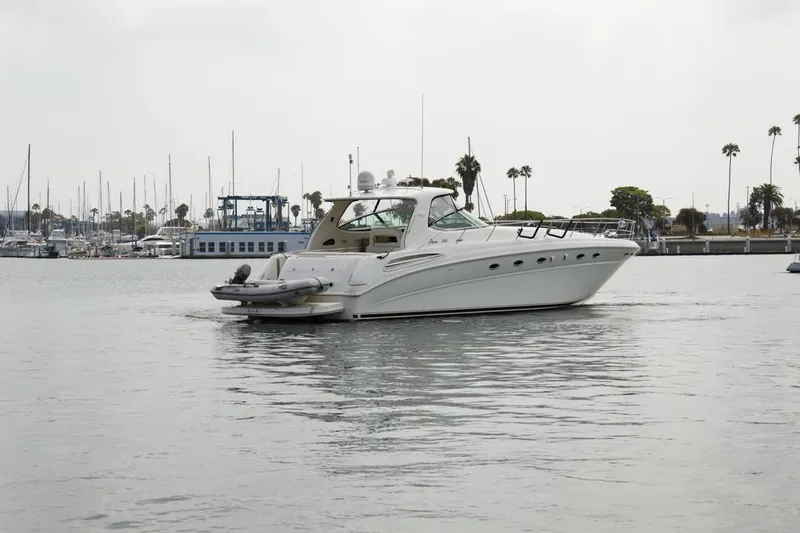  Yacht Photos Pics 2000 Sea Ray 510 Sundancer yacht cruising in a marina with palm trees in the background.