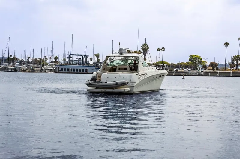  Yacht Photos Pics Sea Ray 510 Sundancer 2000 yacht cruising in a marina with palm trees and docks.