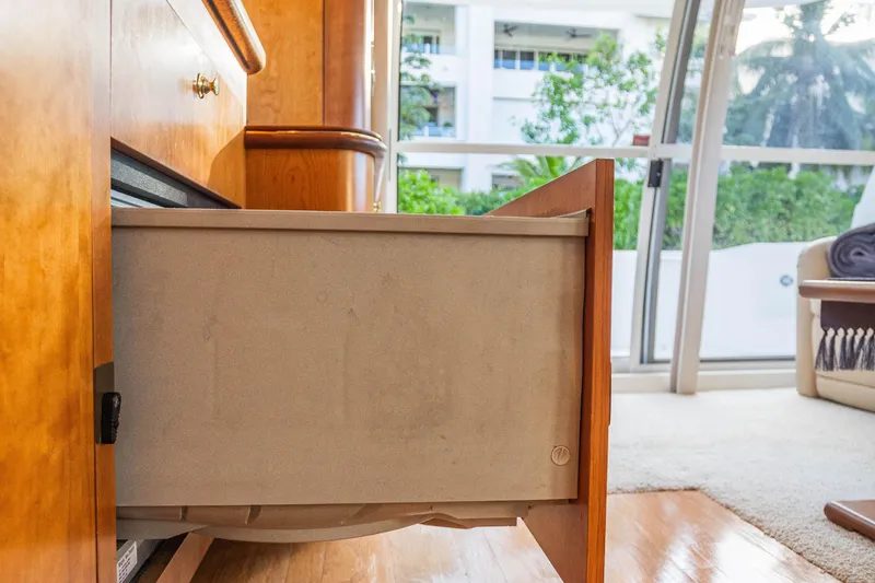  Yacht Photos Pics Open drawer in 2001 Cruisers Yachts 5000 Sedan Sport interior, with wooden cabinetry and window view.