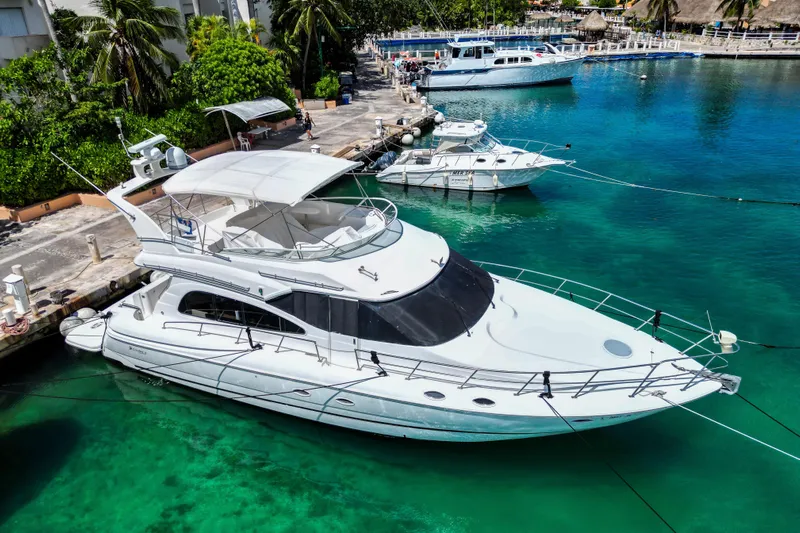  Yacht Photos Pics 2001 Cruisers Yachts 5000 Sedan Sport docked in clear turquoise water.