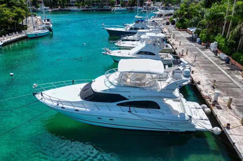  Yacht Photos Pics 2001 Cruisers Yachts 5000 Sedan Sport docked in a vibrant marina.