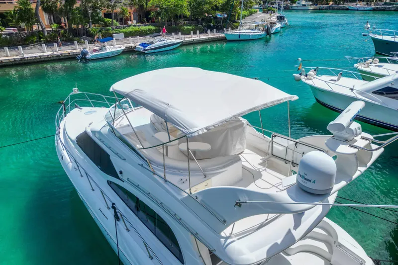  Yacht Photos Pics 2001 Cruisers Yachts 5000 Sedan Sport docked in clear turquoise water.