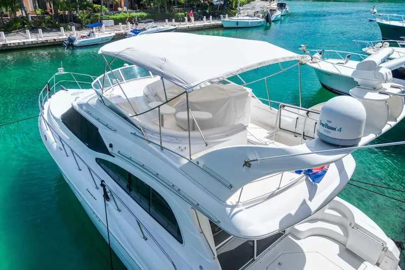  Yacht Photos Pics 2001 Cruisers Yachts 5000 Sedan Sport docked in clear turquoise water.