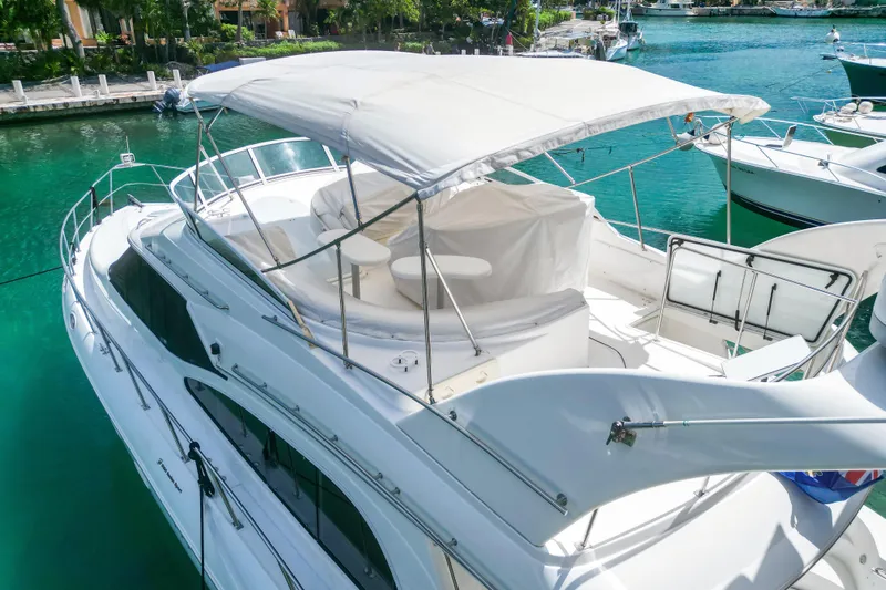  Yacht Photos Pics 2001 Cruisers Yachts 5000 Sedan Sport docked in a serene marina setting.