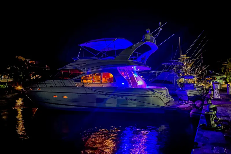 Mimosa Yacht Photos Pics 2001 Cruisers Yachts 5000 Sedan Sport illuminated at night in marina.