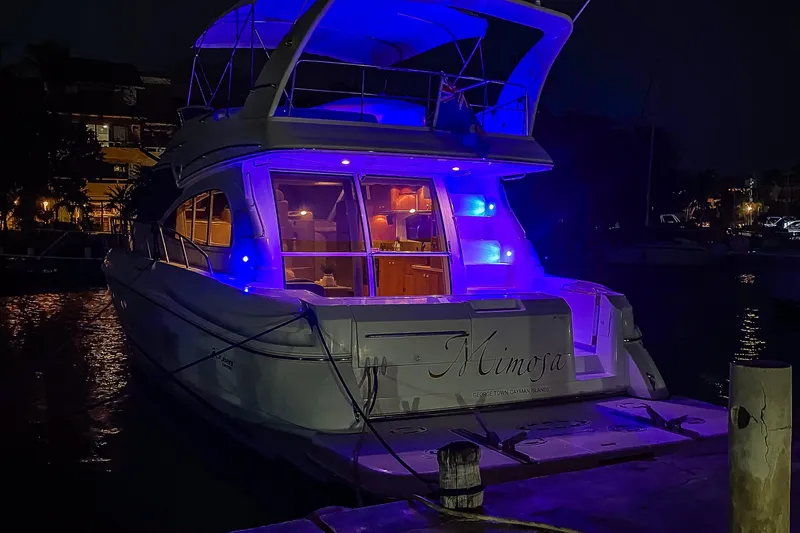 Mimosa Yacht Photos Pics 2001 Cruisers Yachts 5000 Sedan Sport illuminated at night with blue lights.