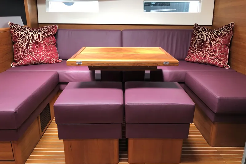 Nausicaä Yacht Photos Pics Luxurious interior of 2019 Solaris Yachts 55 with purple seating and elegant wooden table.