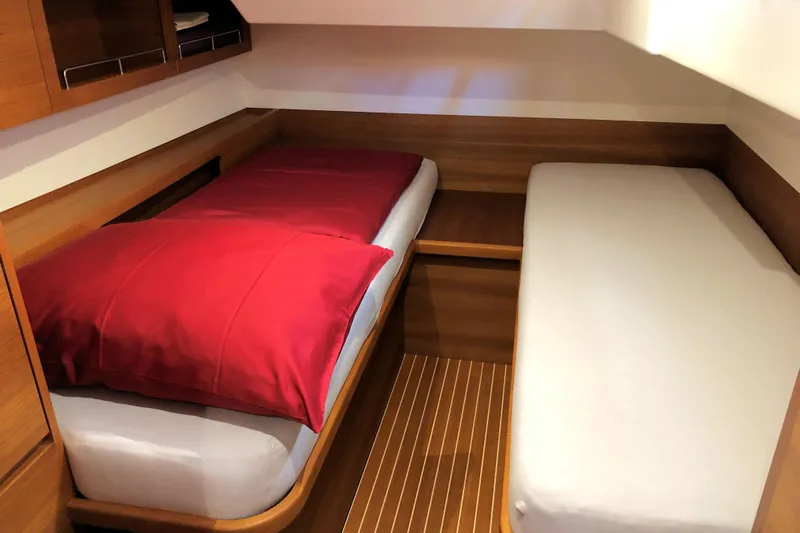 Nausicaä Yacht Photos Pics Cozy twin cabin in 2019 Solaris Yachts 55 with wooden interior and red bedding.