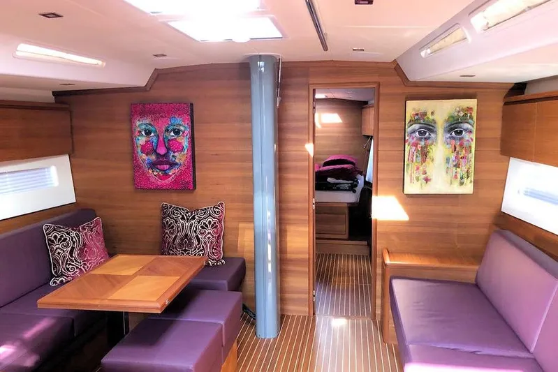 Nausicaä Yacht Photos Pics Luxurious interior of 2019 Solaris Yachts 55 with vibrant artwork and purple seating.
