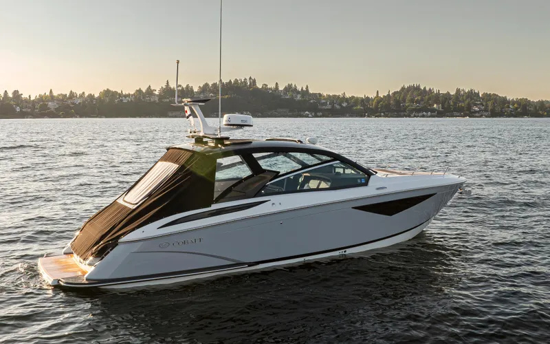 Rancho Agua Yacht Photos Pics 2021 Cobalt A36 boat cruising on a calm lake at sunset.