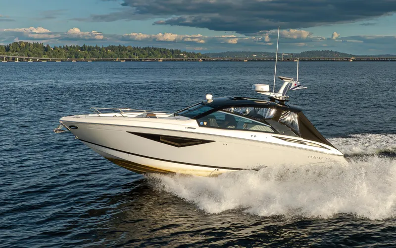 Rancho Agua Yacht Photos Pics 2021 Cobalt A36 boat cruising on a scenic lake under a partly cloudy sky.