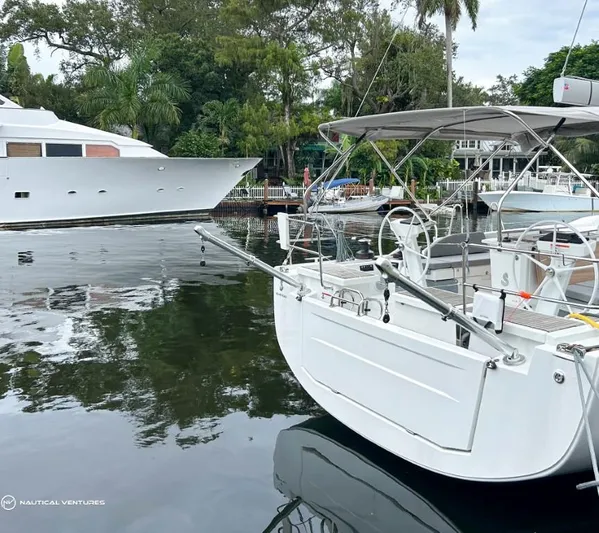  Yacht Photos Pics 2024 Beneteau Oceanis 51.1 yacht docked in a serene marina setting.