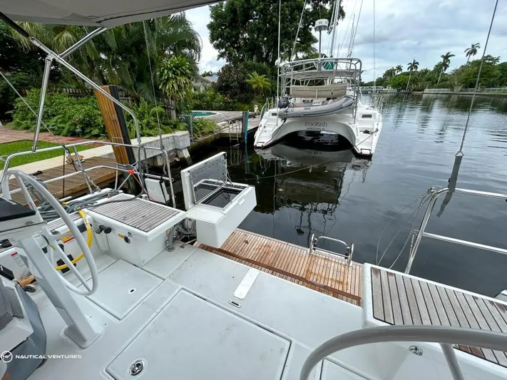  Yacht Photos Pics Beneteau Oceanis 51.1 yacht deck, 2024 model, docked by a lush, tropical canal.