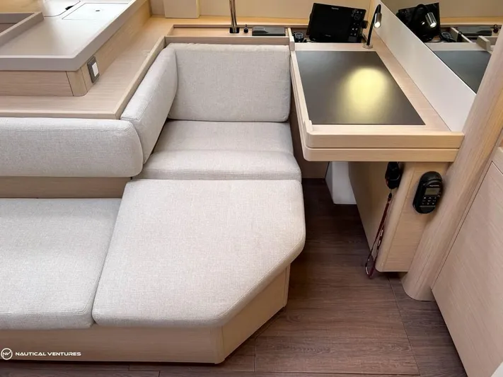  Yacht Photos Pics Interior of 2024 Beneteau Oceanis 51.1 yacht with beige seating and navigation station.
