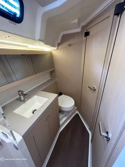  Yacht Photos Pics 2024 Beneteau Oceanis 51.1 yacht bathroom with modern fixtures and wood accents.
