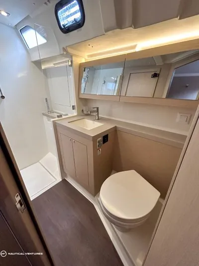  Yacht Photos Pics Modern bathroom in 2024 Beneteau Oceanis 51.1 yacht with sleek fixtures and ample lighting.