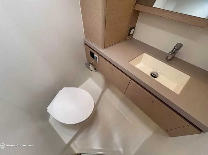  Yacht Photos Pics Modern bathroom in 2024 Beneteau Oceanis 51.1 yacht with sleek sink and toilet.