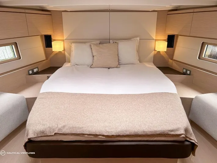  Yacht Photos Pics Luxurious bedroom interior of 2024 Beneteau Oceanis 51.1 yacht with cozy lighting.