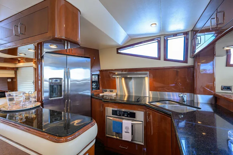 Vol Aboard Yacht Photos Pics Luxurious kitchen interior of 2005 Marquis 65 MY yacht with modern appliances and sleek design.