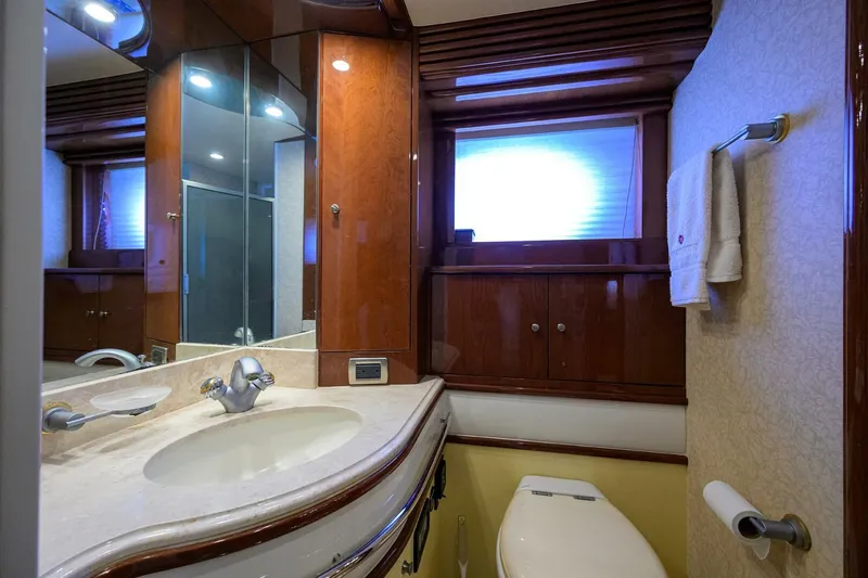 Vol Aboard Yacht Photos Pics Luxurious bathroom in 2005 Marquis 65 MY yacht with elegant wood finishes and modern fixtures.