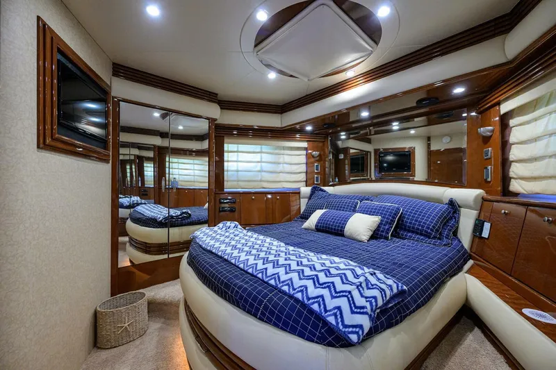 Vol Aboard Yacht Photos Pics Luxurious bedroom interior of 2005 Marquis 65 MY yacht with elegant bedding and wood accents.
