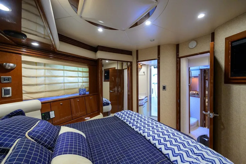 Vol Aboard Yacht Photos Pics Luxurious bedroom interior of 2005 Marquis 65 MY yacht with elegant bedding and wood accents.