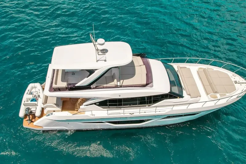 Macu Yacht Photos Pics 2024 Ferretti Yachts 580 cruising on clear blue water, aerial view.