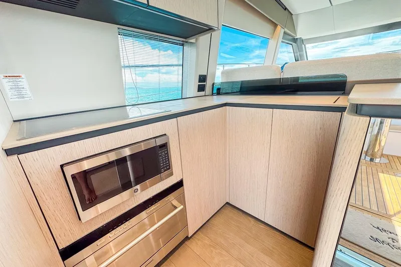 Macu Yacht Photos Pics Modern kitchen interior of 2024 Ferretti Yachts 580, featuring sleek cabinetry and ocean view.
