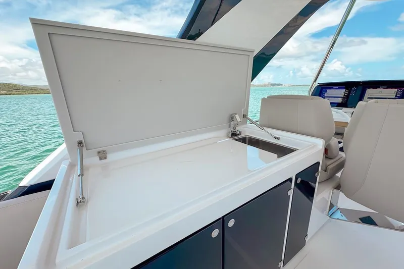 Macu Yacht Photos Pics 2024 Ferretti Yachts 580 interior with open cabinet and sink, overlooking serene waters.