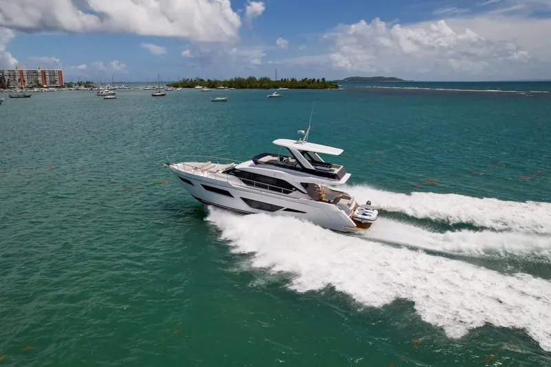 Macu Yacht Photos Pics 2024 Ferretti Yachts 580 cruising on turquoise waters under a partly cloudy sky.
