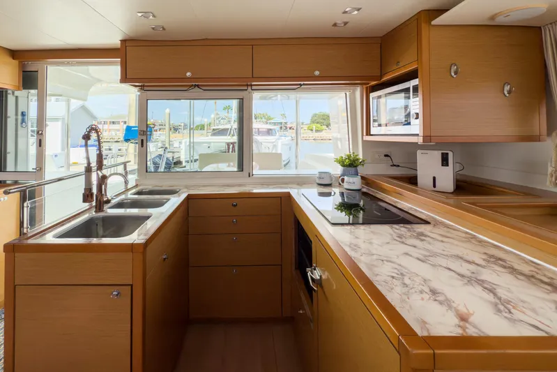  Yacht Photos Pics Modern kitchen interior of 2012 Lagoon 450 F yacht with marble countertops and wooden cabinetry.