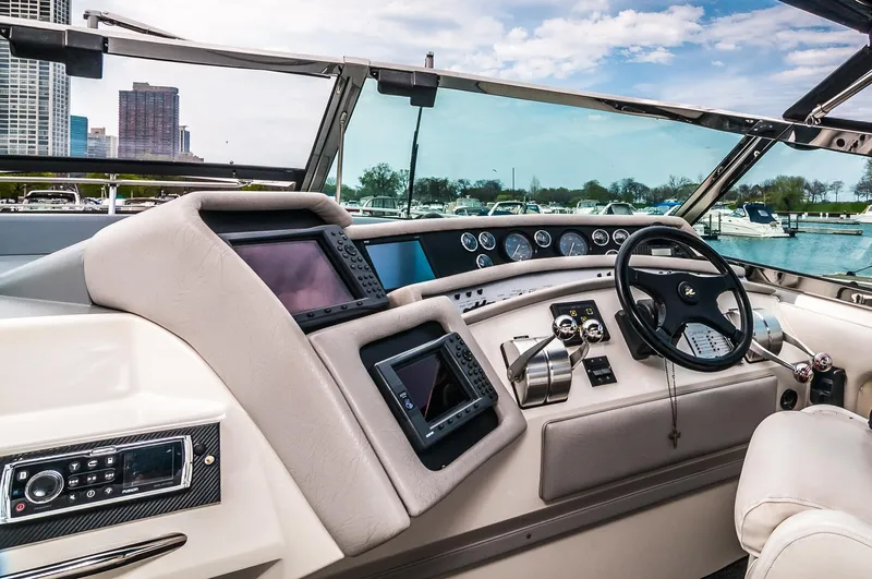  Yacht Photos Pics Helm of 1994 Sea Ray 500 Sundancer with modern navigation equipment and city skyline in background.
