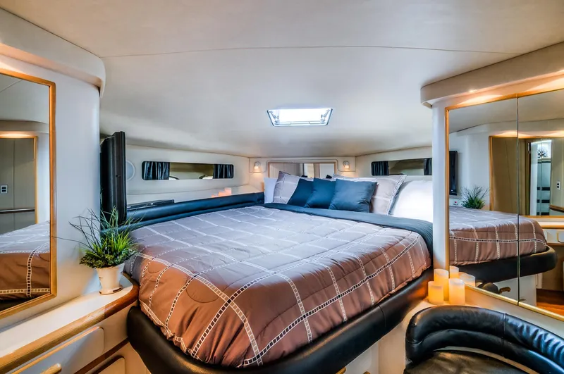  Yacht Photos Pics Luxurious bedroom interior of 1994 Sea Ray 500 Sundancer yacht with skylight and modern decor.