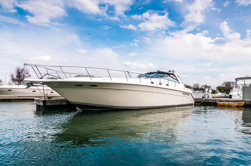  Yacht Photos Pics 1994 Sea Ray 500 Sundancer yacht docked in a marina under a blue sky.