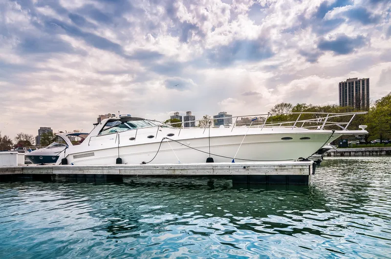  Yacht Photos Pics 1994 Sea Ray 500 Sundancer yacht docked at a marina under a cloudy sky.