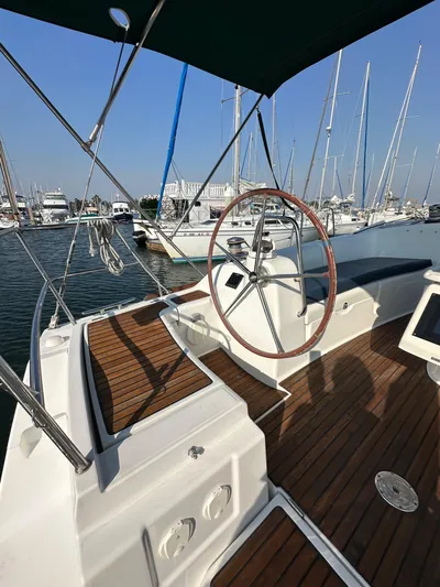 Shamrock Yacht Photos Pics 2011 Beneteau Oceanis 40 sailboat cockpit with wooden deck and steering wheel in marina.