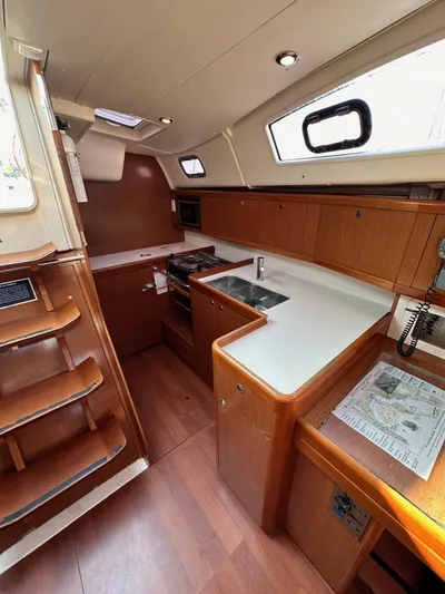 Shamrock Yacht Photos Pics Interior of 2011 Beneteau Oceanis 40 sailboat with modern kitchen and wooden cabinetry.