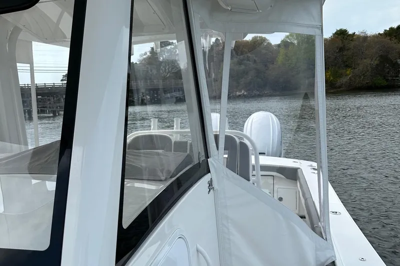 Grey Ghost Yacht Photos Pics 2023 Regulator 34 boat on calm water, featuring sleek design and clear enclosure.