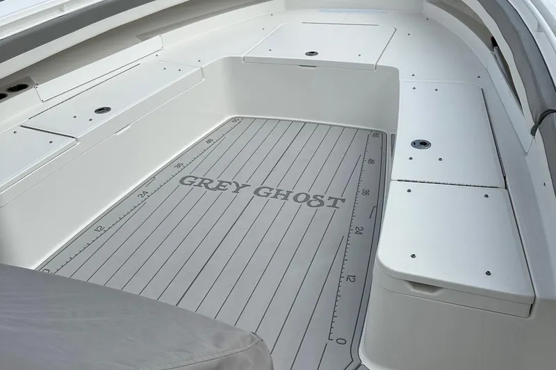Grey Ghost Yacht Photos Pics 2023 Regulator 34 boat deck with "Grey Ghost" branding and storage compartments.