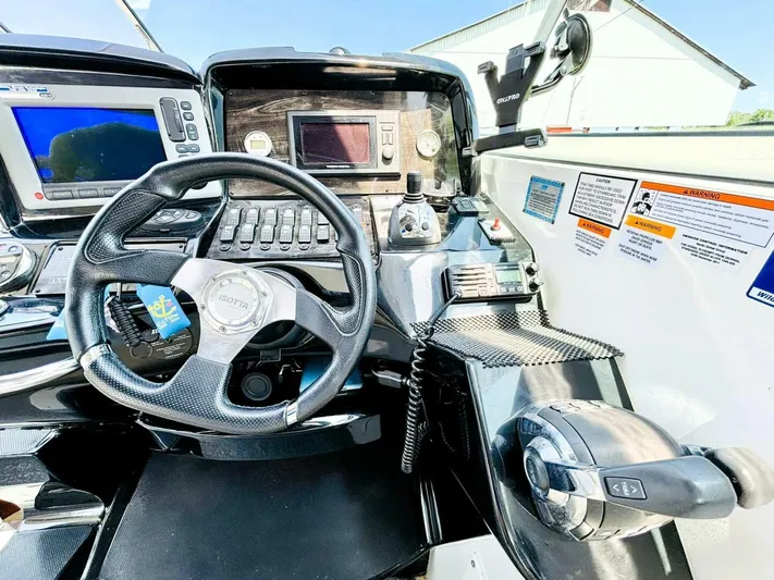  Yacht Photos Pics Control panel of a 2012 Rinker 310 Fiesta Vee boat with steering wheel and navigation equipment.
