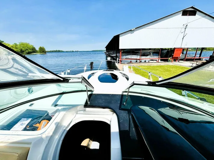  Yacht Photos Pics 2012 Rinker 310 Fiesta Vee boat docked by a lakeside marina under clear blue skies.