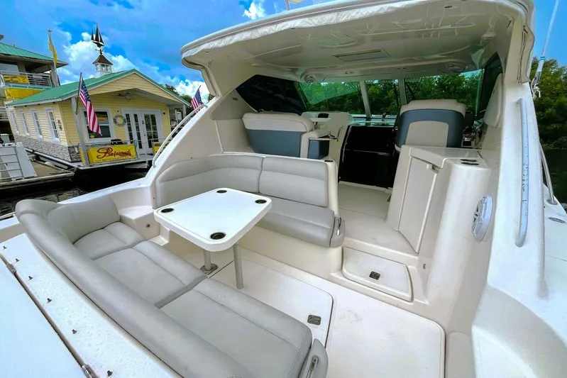  Yacht Photos Pics 2007 Tiara 3900 Sovran yacht with spacious seating and table, docked near a building.