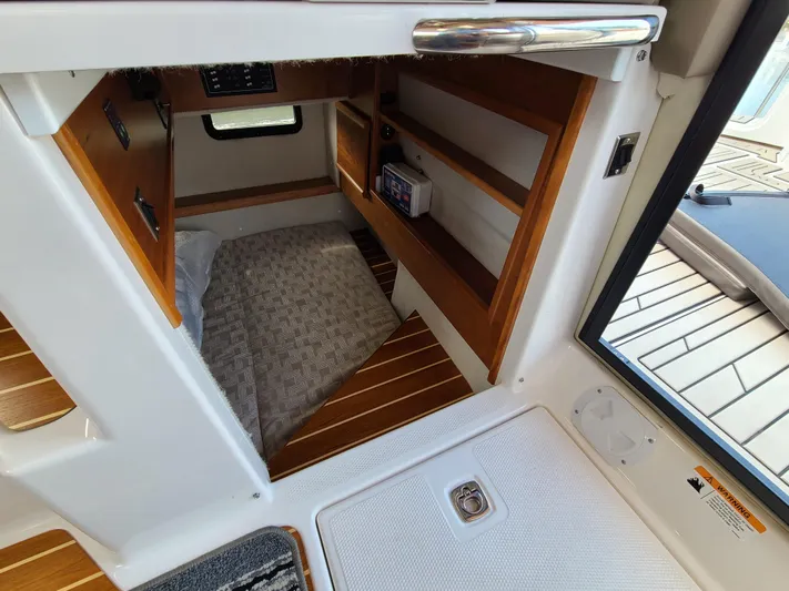  Yacht Photos Pics 2023 Cutwater C-30 Sedan NW Edition cabin interior with wooden shelves and cozy bedding.