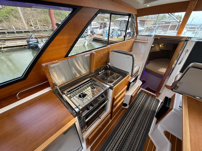  Yacht Photos Pics 2023 Cutwater C-30 Sedan NW Edition interior with kitchen and seating area.